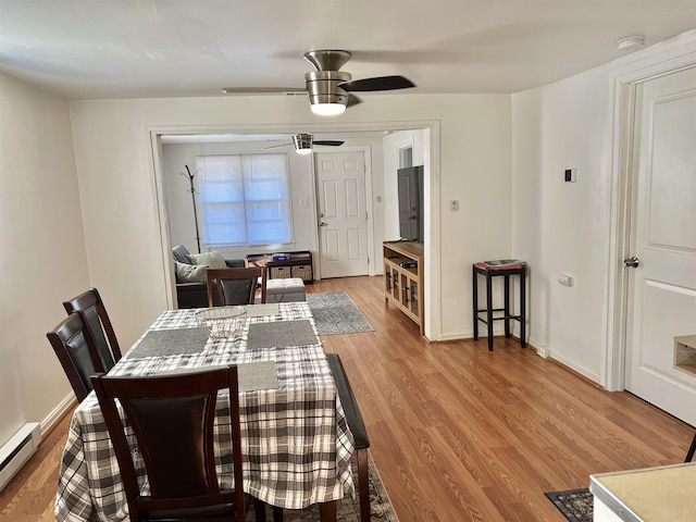 dining area featuring baseboard heating, ceiling fan, and light hardwood / wood-style flooring