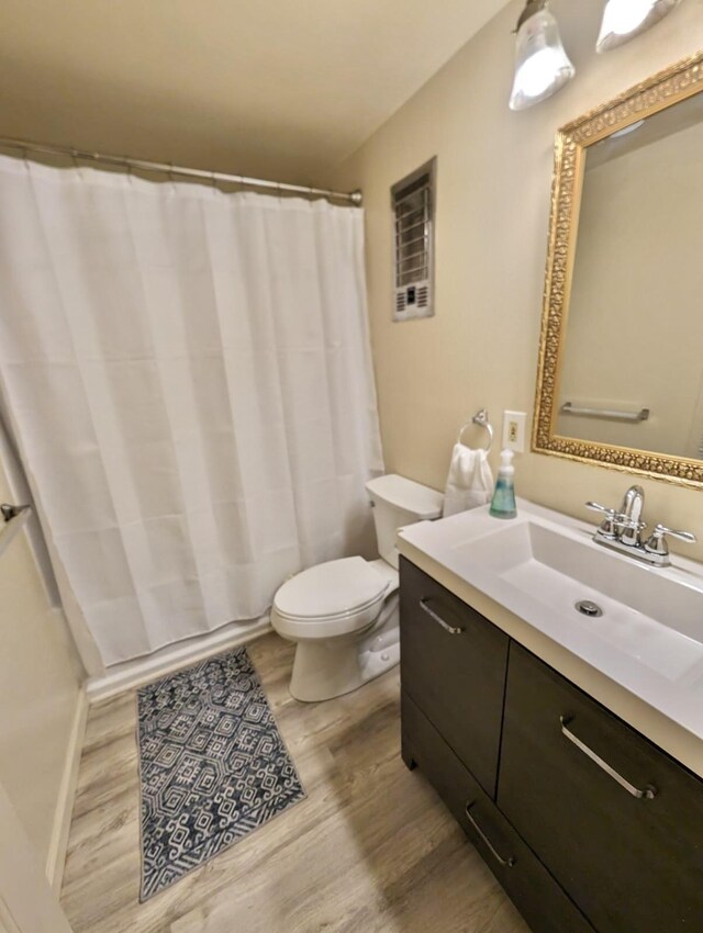 bathroom featuring a shower with curtain, vanity, wood-type flooring, and toilet