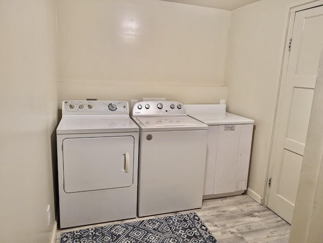 clothes washing area featuring washer and dryer and light wood-type flooring