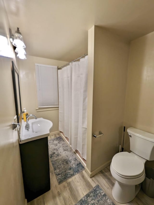 bathroom with hardwood / wood-style floors, vanity, toilet, and a shower with shower curtain