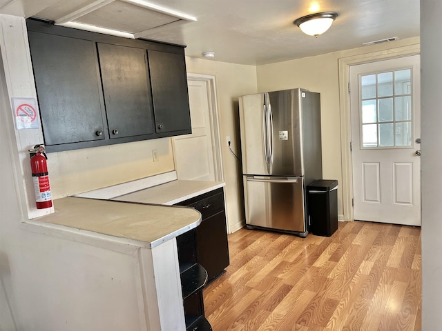 kitchen with light wood-type flooring and stainless steel refrigerator