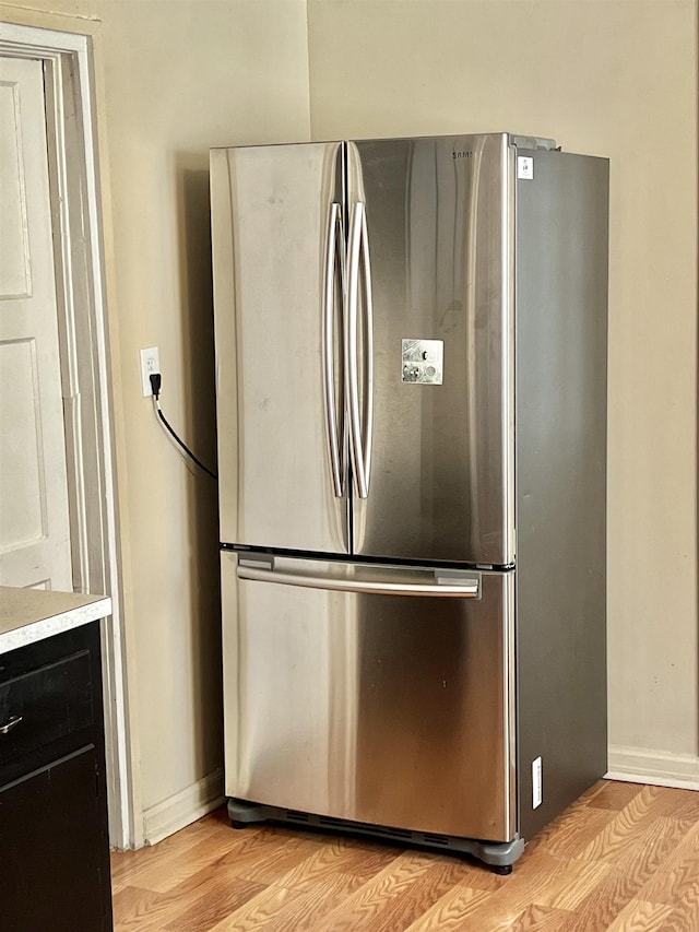 kitchen with light wood-type flooring and stainless steel refrigerator