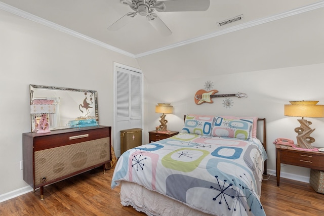 bedroom featuring ceiling fan, crown molding, hardwood / wood-style floors, a closet, and lofted ceiling