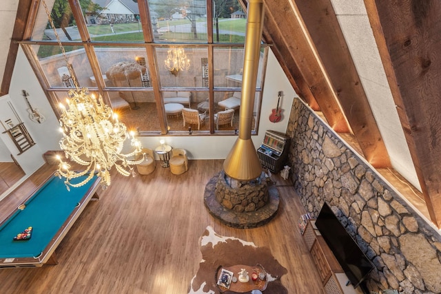 interior details with a stone fireplace, an inviting chandelier, and hardwood / wood-style flooring