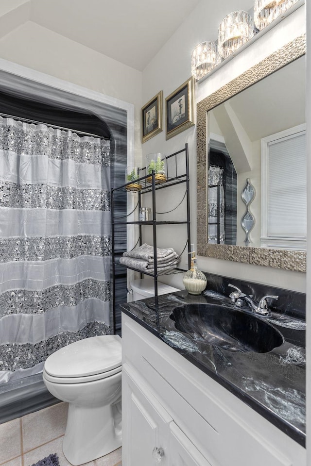 bathroom featuring tile patterned flooring, vanity, toilet, and walk in shower