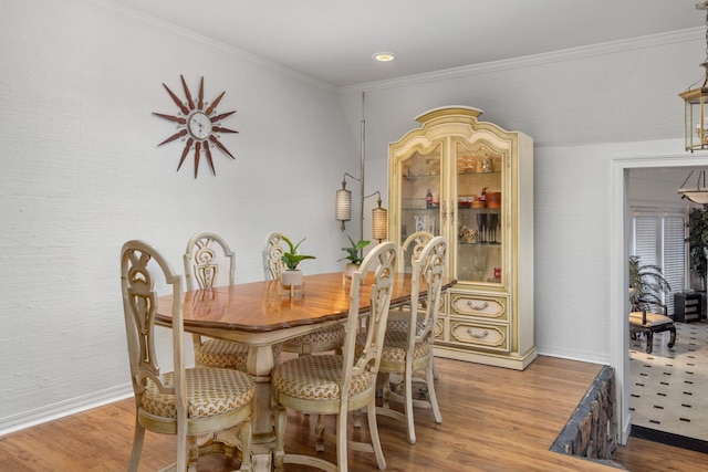 dining space featuring hardwood / wood-style flooring and crown molding