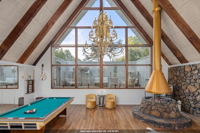 rec room with high vaulted ceiling, a notable chandelier, wood finished floors, beam ceiling, and a wood stove