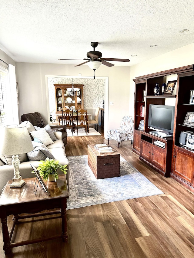  - living room featuring a ceiling fan, wood finished floors, and a textured ceiling