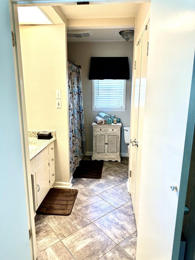  - bathroom with vanity, toilet, baseboards, and curtained shower