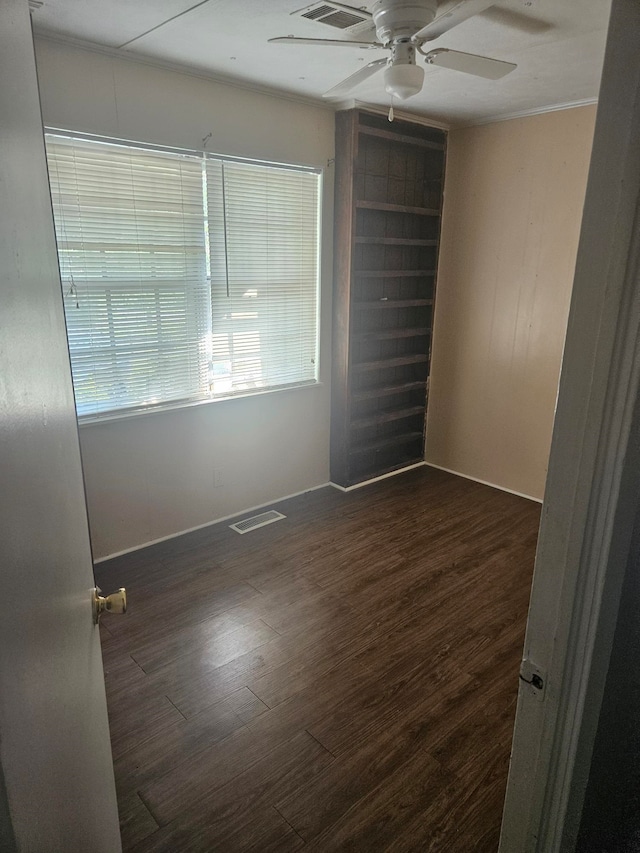 spare room with ceiling fan, crown molding, and dark hardwood / wood-style floors