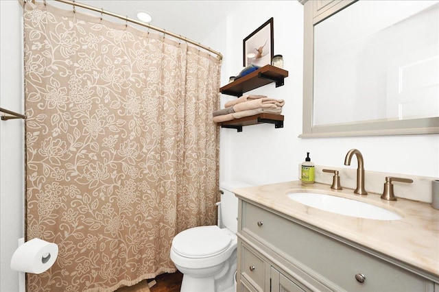  - bathroom with toilet, vanity, and a shower with curtain