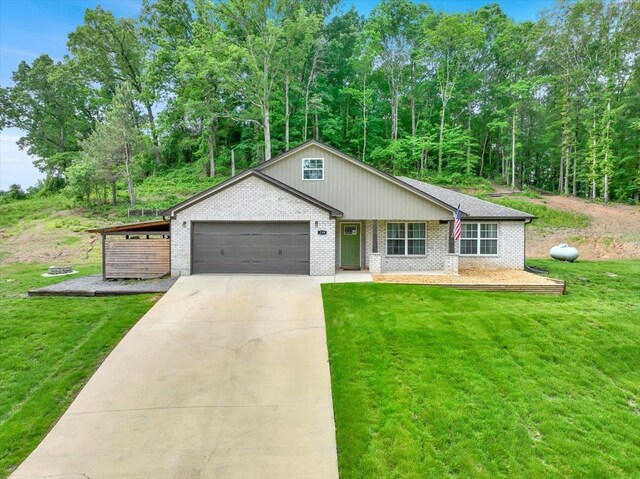  - view of front of home with brick siding, an attached garage, concrete driveway, and a front yard