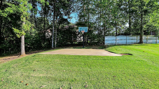 view of sport court with a yard