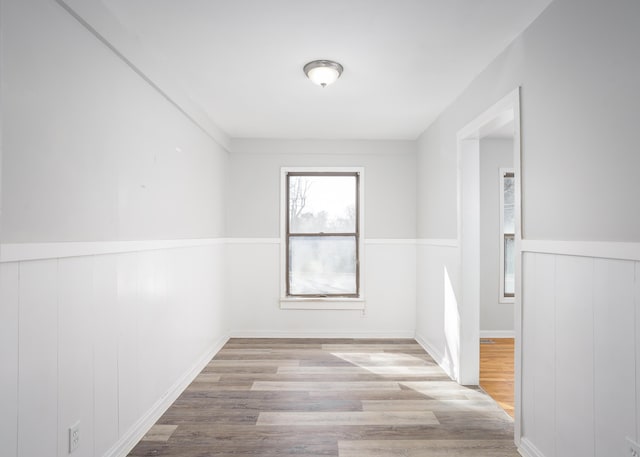 empty room featuring wainscoting and wood finished floors