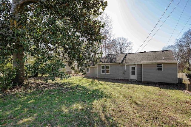 back of property with a yard and fence