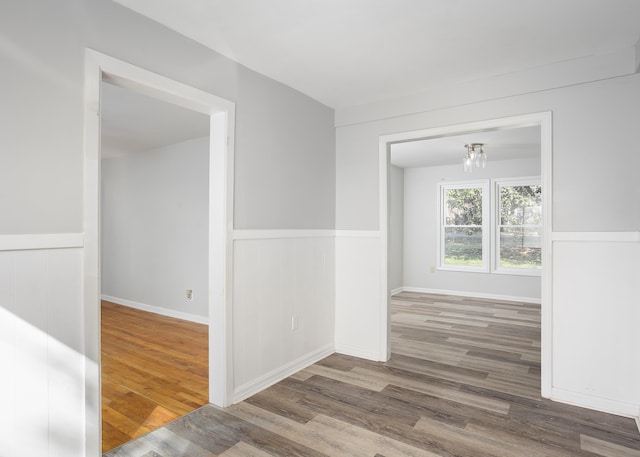 unfurnished room featuring wainscoting and wood finished floors