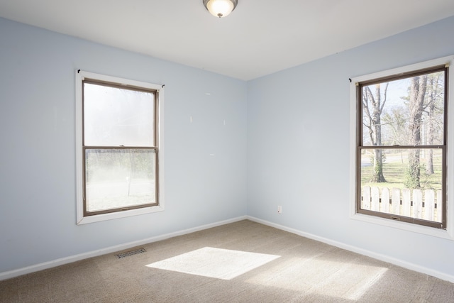 empty room featuring carpet flooring, baseboards, and visible vents