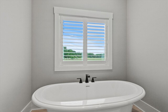bathroom with baseboards and a freestanding bath