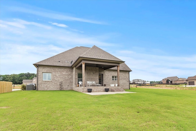 rear view of house with a patio area, a yard, central air condition unit, and brick siding