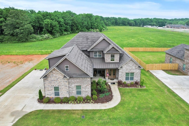 craftsman house with a standing seam roof, brick siding, metal roof, and driveway