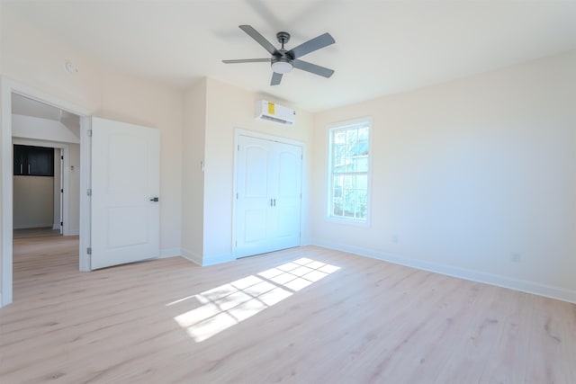  - unfurnished bedroom featuring light wood-style floors, a wall unit AC, a closet, and a ceiling fan