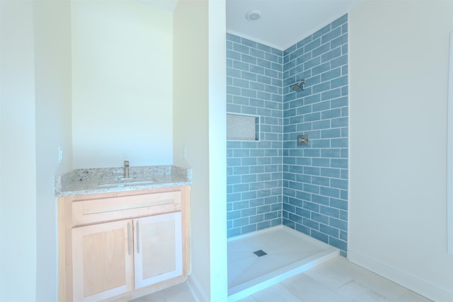  - full bath featuring tiled shower, vanity, and tile patterned floors