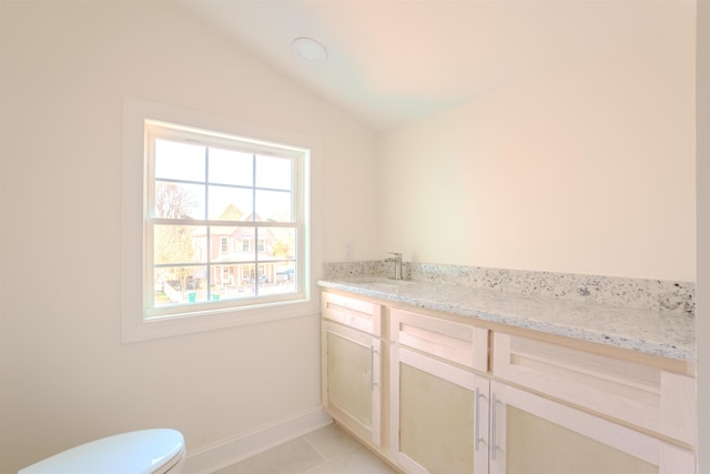  - bathroom with tile patterned floors, vanity, and lofted ceiling