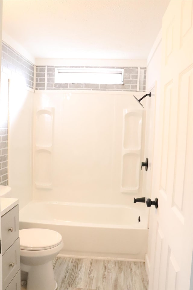 full bathroom with bathtub / shower combination, vanity, toilet, and wood finished floors