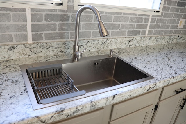 details featuring light stone counters and a sink