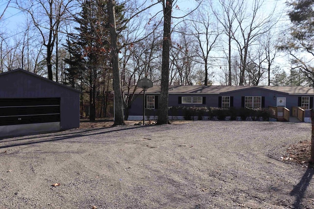 single story home featuring a detached garage and an outdoor structure