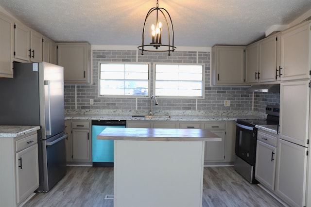 kitchen featuring light countertops, electric range oven, freestanding refrigerator, a sink, and dishwashing machine