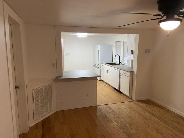 kitchen with white cabinetry, sink, ceiling fan, light hardwood / wood-style floors, and white appliances