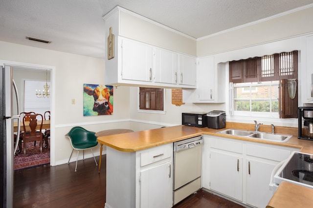 kitchen with visible vents, an inviting chandelier, a sink, white appliances, and a peninsula