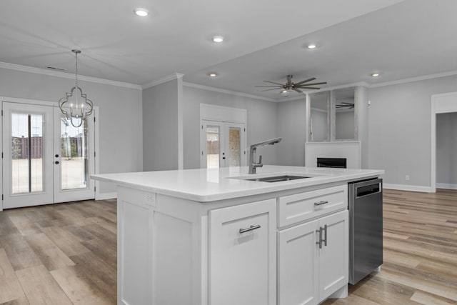 kitchen with crown molding, recessed lighting, french doors, white cabinetry, and a sink