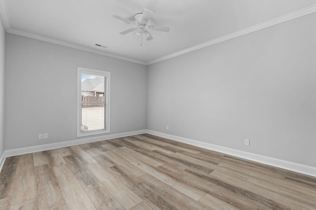 empty room featuring baseboards, visible vents, light wood finished floors, ceiling fan, and crown molding