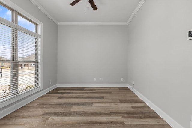 empty room featuring crown molding, wood finished floors, and a healthy amount of sunlight