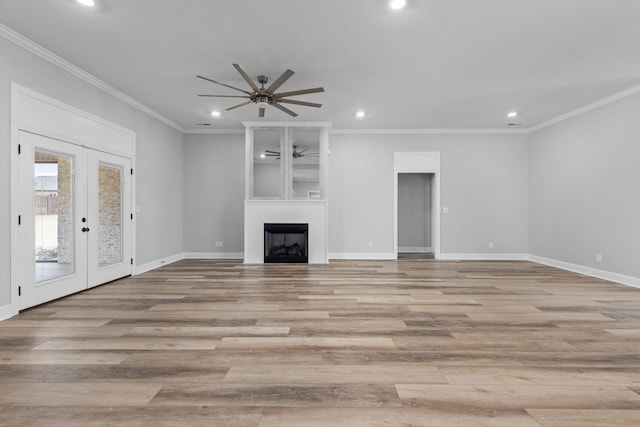 unfurnished living room with recessed lighting, crown molding, and a large fireplace