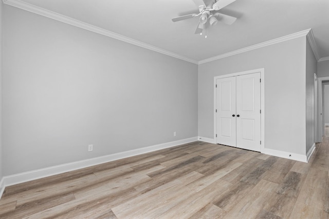 unfurnished bedroom with ceiling fan, baseboards, ornamental molding, wood finished floors, and a closet