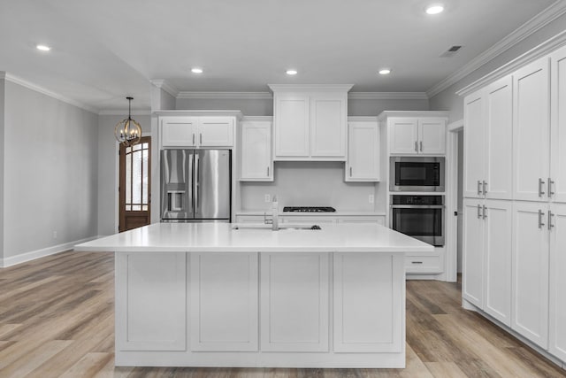 kitchen with ornamental molding, white cabinetry, stainless steel appliances, and a sink