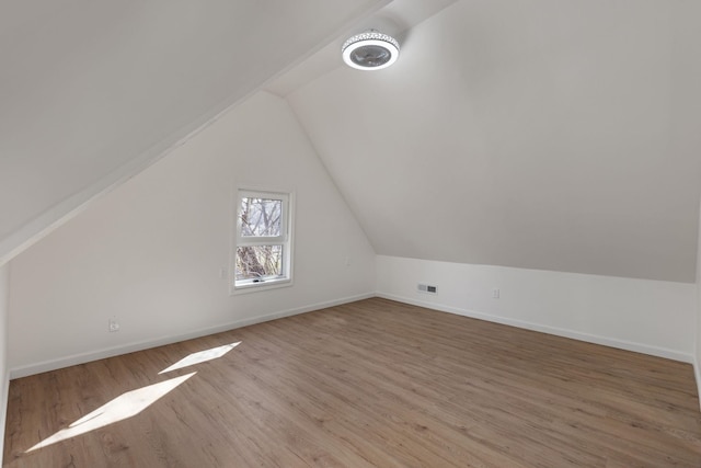  - additional living space with vaulted ceiling, wood finished floors, and baseboards