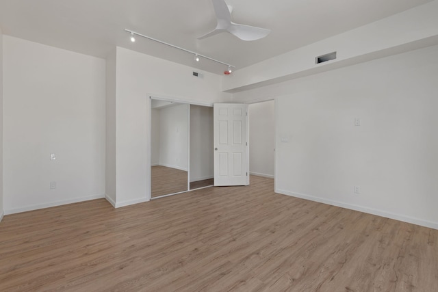  - empty room with rail lighting, ceiling fan, light wood finished floors, and baseboards