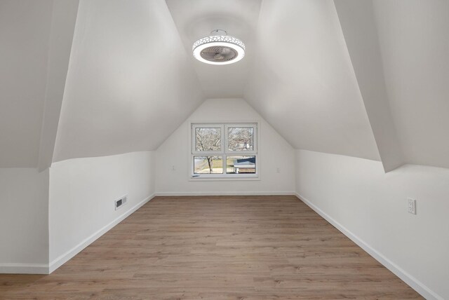  - additional living space with vaulted ceiling, light wood-type flooring, and baseboards