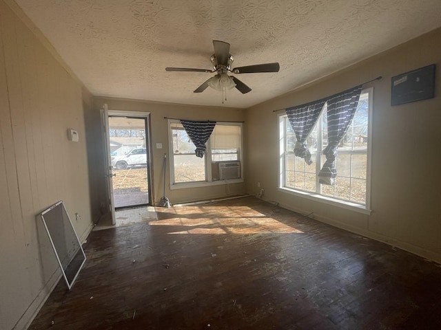 unfurnished room featuring cooling unit, ceiling fan, wood-type flooring, and a textured ceiling