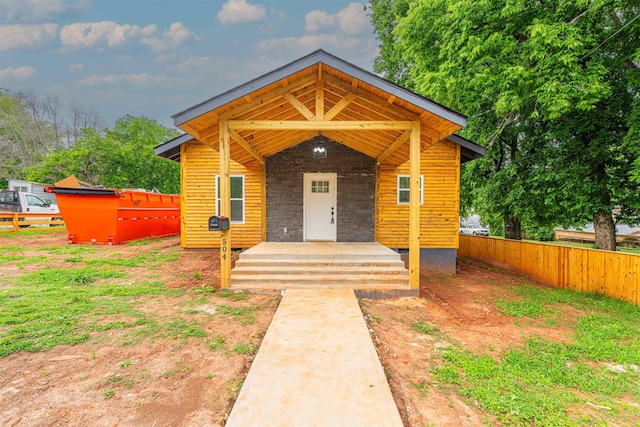 - view of front facade featuring fence and covered porch