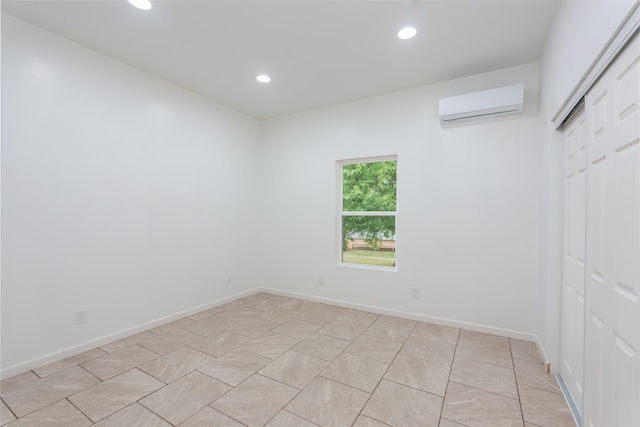  - unfurnished room with a wall mounted air conditioner, recessed lighting, and baseboards