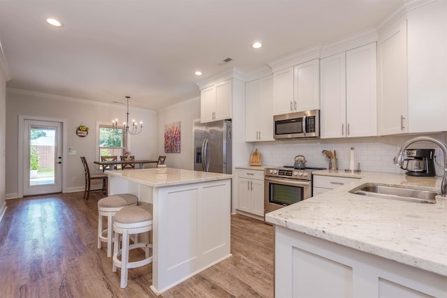 181 Silver Leaf Ln, Florence, AL - kitchen featuring appliances with stainless steel finishes, white cabinets, tasteful backsplash, a center island, and ornamental molding