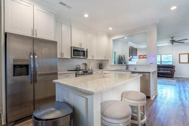 181 Silver Leaf Ln, Florence, AL - kitchen featuring appliances with stainless steel finishes, a kitchen island, a kitchen bar, white cabinetry, and a ceiling fan
