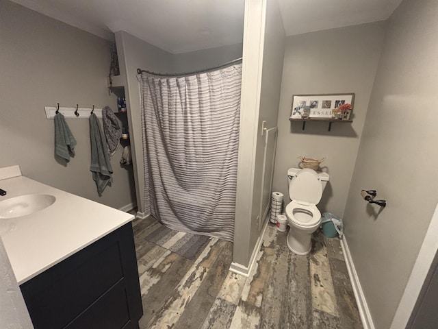 bathroom featuring hardwood / wood-style flooring, toilet, vanity, and a shower with shower curtain