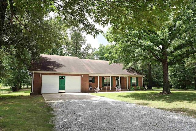  - ranch-style house with gravel driveway, covered porch, a front lawn, and brick siding