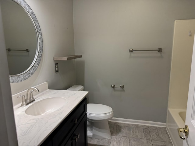 bathroom featuring baseboards, vanity, and toilet